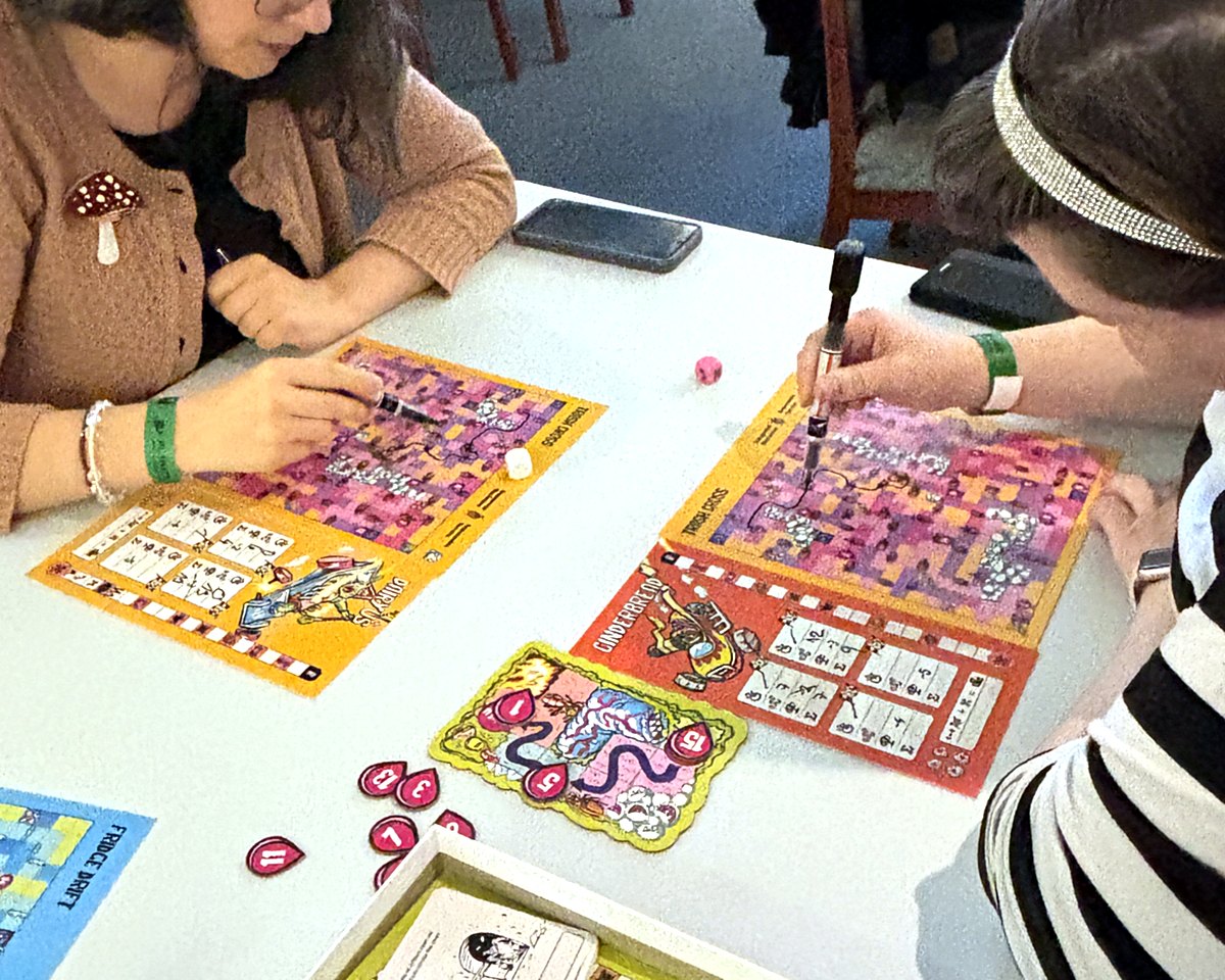 Two players drawing their routes on Kitchen Rally maps at the same time