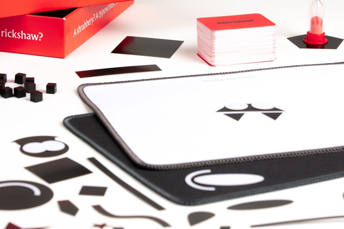 Shapemash components: word cards, plastic shapes, neoprene canvases, sand timer and scoring cubes